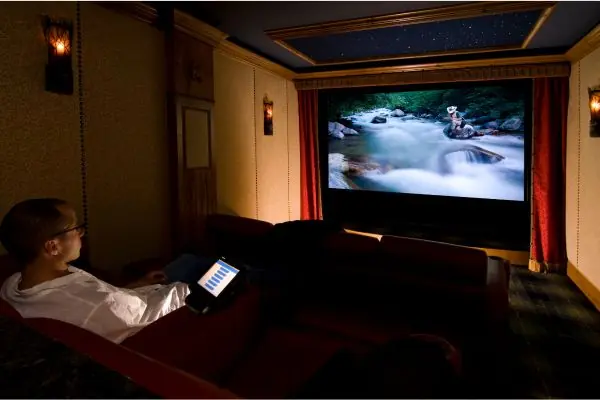 man sitting alone watching movies on big screen