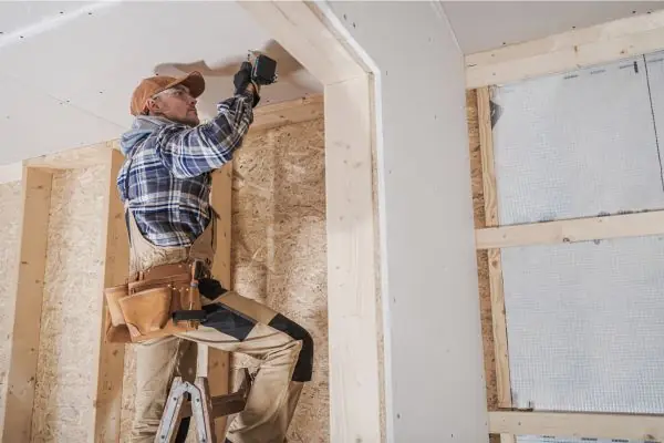 construction worker renovating basement ceiling