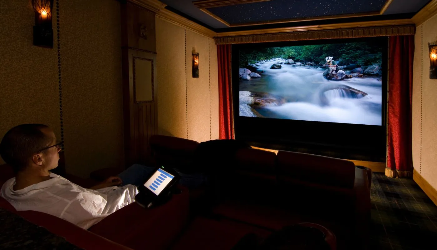 home owner relaxing and watching movie in his basement home theater