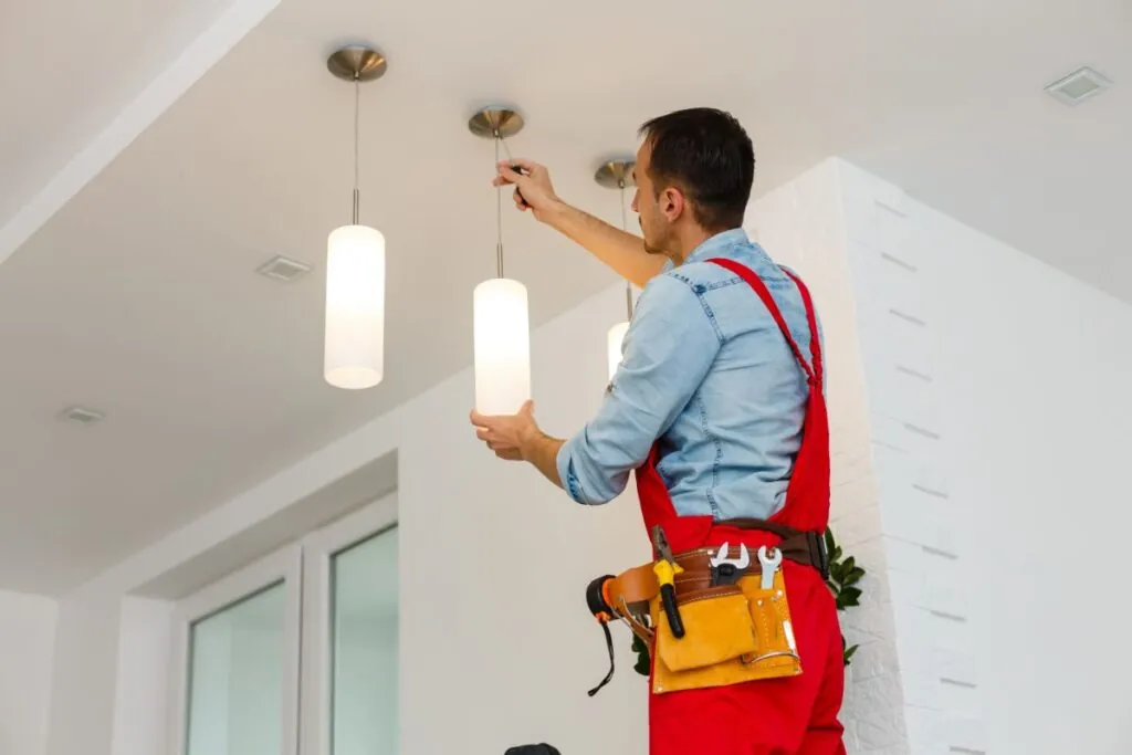 electrician installing ceiling lamp on the basement